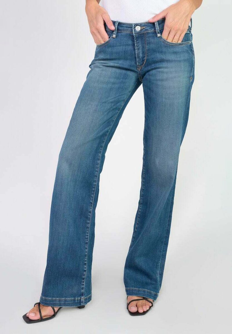 Jean en denim bleu clair, évasé, avec une conception à cinq poches, fermeture à bouton et lavage moyen. Texture lisse et coupe droite de la genou à l'ourlet.