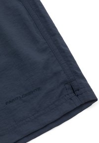 Granatowe szorty wykonane z lekkiego materiału o subtelnej fakturze, z przeszytymi szwami i małym logo w pobliżu dołu.