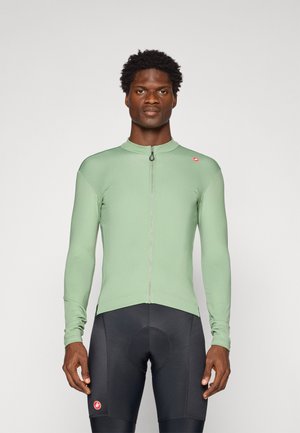 Long-sleeve cycling jersey in light green, featuring a front zipper and slim fit. Paired with black cycling shorts, highlighting athletic design.