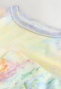 Lühikeste varrukatega pastelltoonides batiktriibuline särk pehmest puuvillast, millel on mitmevärviline abstraktne muster. Omadusteks on ümar kaelus ja sile pind.