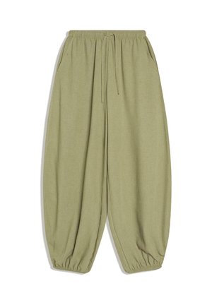 Pantalon vert ample en tissu doux. Il comporte une taille élastique avec cordon de serrage, des poches latérales et des poignets resserrés.