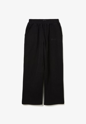 Schwarze weite Sweatpants mit elastischem Bund und Seitentaschen, mit subtilen Textdetails auf dem oberen linken Oberschenkel.