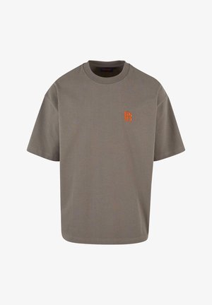 Harmaa lyhythihainen t-paita, jossa on pyöreä kaula-aukko; vasemmassa rintapielessä on oranssi brodeerattu logo; valmistettu pehmeästä puuvillakankaasta.