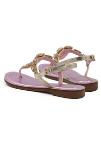 Sandali piatti color oro con una soletta metallica rosa, caratterizzati da decorazioni in perline e una cintura con fibbia alla caviglia per una vestibilità sicura.