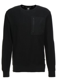 Sudadera negra con un diseño texturizado, cuello redondo, mangas largas y un bolsillo con cremallera en el lado izquierdo del pecho. Acabado de tela suave.