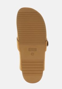 Sandale à glissière beige avec une semelle en caoutchouc texturée. Dotée d'un logo de marque et d'une seule bride en daim traversant le cou-de-pied. Taille 37.