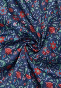 Bloemenstof met een marineblauwe achtergrond en complexe patronen van rode, blauwe en groene bloemen. Zachte textuur met een subtiele glans en mooie val.