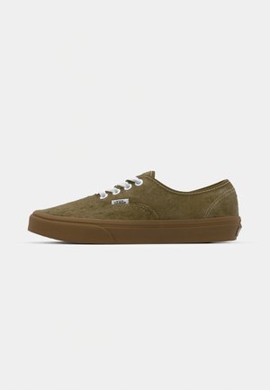 Olive green suede sneakers with white laces, rubber brown outsole, low-top design, and stitched detailing along the edges.