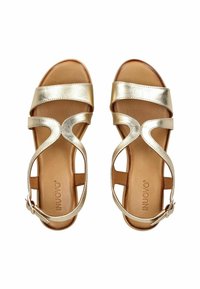 Metalické zlaté sandály s hladkým povrchem, které mají tři nastavitelná popruhy a částečný podpatek. Stélka je v barvě světle hnědé.