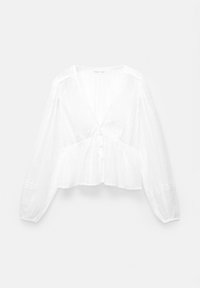 Blouse blanche à manches longues avec des rayures verticales texturées, décolleté en V, fermeture à boutons et ourlet légèrement évasé sur un fond uni.
