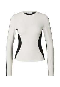 Langsleeve top in het wit met zwarte zijkanten, ronde hals, getailleerd ontwerp en een gladde textuur. Geen patronen of hardware zichtbaar.