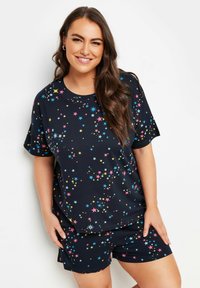 Kortärmad pyjamas i marinblått med färgglada stjärnmönster. Toppens halsringning är rund och shortsen har ett elastiskt midjeband.