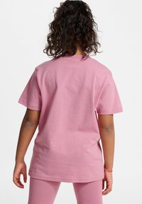Lyserød bomulds T-shirt med korte ærmer, rund halsudskæring og en afslappet pasform. Glat tekstur og enkelt design. Velegnet til hverdagstøj.