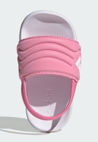 Růžové nazouvací sandály s texturovaným svrškem, elastickou stuhou a bílou podrážkou. Mají výrazné logo a hladkou, polstrovanou stélku.