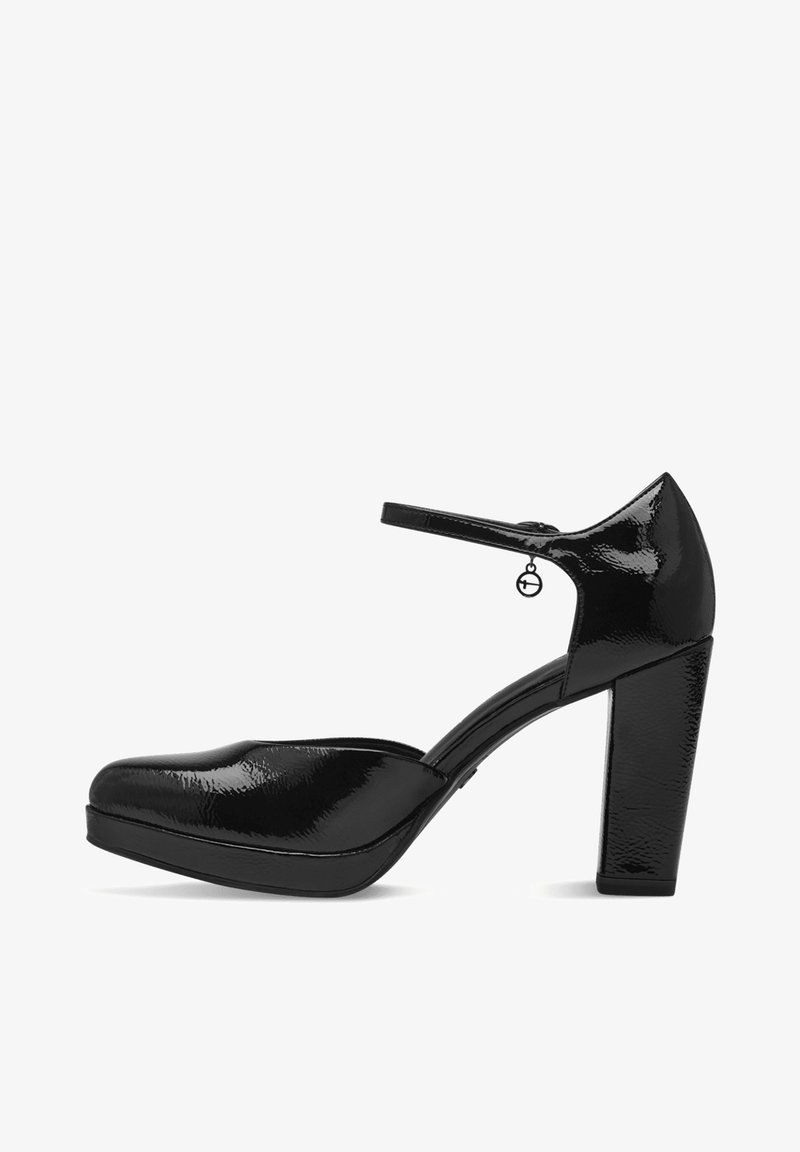 Chaussure Mary Jane en cuir verni noir avec talon haut épais, semelle plateforme et bride à la cheville ornée d'un petit pendentif rond.