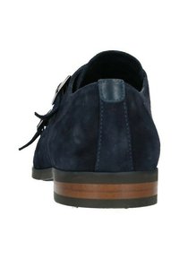 Marineblauwe suède schoen met een gestapelde bruine houten hak. Kenmerkt zich door een zachte leren accent aan de achterkant en decoratieve veters aan de zijkanten.