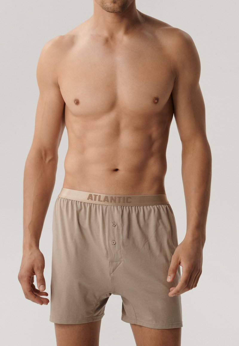 Beżowe bokserki z guzikiem i elastycznym pasem, z logo "ATLANTIC". Miękka tkanina, prosty krój i gładka faktura.