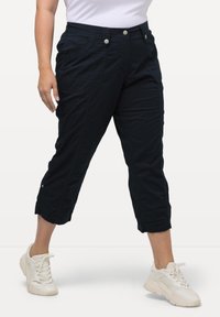 Marina capribyxor med avslappnad passform, med fickor, frontkn�äppning och tryckknappsdetaile vid anklarna. Kombineras med vita sneakers.