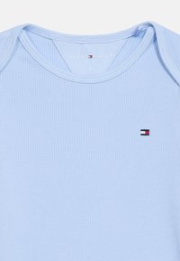 Βρεφικό κορμάκι από γαλάζιο ριμπ βαμβάκι με το λογότυπο Tommy Hilfiger στο στήθος και ετικέτα τυπωμένη στο εσωτερικό του γιακά.