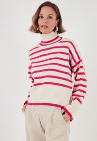 Ribaga pullover-sviiter kreemi ja fuksiaroosa triibuga, millel on kõrge kaelus, soonikkoes äär ja lõdva istuvusega rippuvad õlad.
