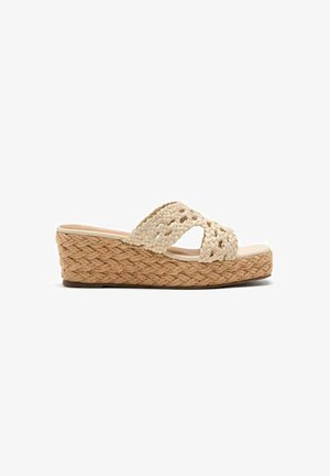 Sandalias de cuña beige con tiras superiores trenzadas y una suela de plataforma de yute texturizado y tejido. Plantilla suave y plana.