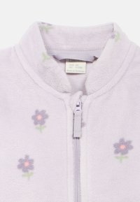 Jasnofioletowa bluza polarowa z kwiatowym wzorem, zawierająca małe kwiaty w ciemnofioletowym i różowym kolorze z zielonymi łodygami oraz zamkiem błyskawicznym z przodu.