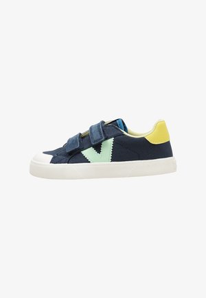 Sneaker blu navy con suola bianca, logo laterale verde menta, toppa gialla sul tallone e due strap blu navy con chiusura a strappo.