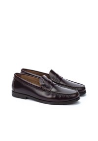 Mocasines de piel marrón con suela plana, que presentan un diseño cosido y una banda decorativa en la parte superior. Textura suave en todo.