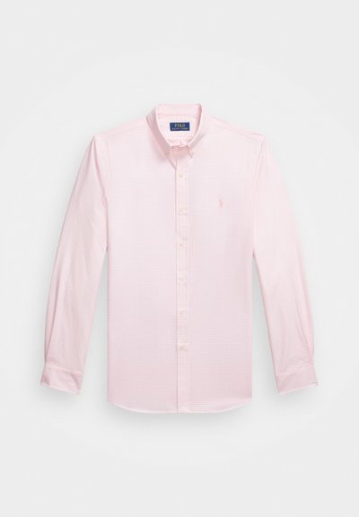 Gaiši rozā, ilgu piedurkņu krekliņš ar mazu pārbaudījumu rakstu, pogājama apkakle un izšūta logo kreisajā krūtī. Kokvilnas materiāls.