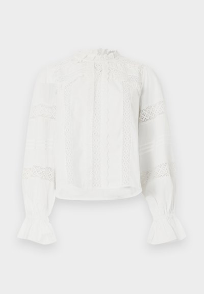 Λευκό μπλούζα με μακριά μανίκια και δαντελένιες λεπτομέρειες, με ψηλό γιακά με βολάν και φαρδιά μανσέτα, που διαθέτει κάθετες ρίγες από δαντέλα στο μπροστινό μέρος και στα μανίκια.