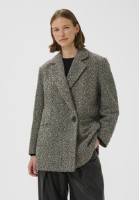 Wollen blend jas in een zwart-wit houndstooth patroon, met een ingesneden kraag, dubbele knoopsluiting en voorzakken.
