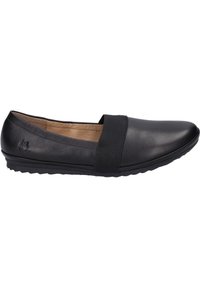 Chaussure slip-on en cuir noir avec bande élastique, bout arrondi, semelle texturée et petit talon. Présente une finition lisse et un branding minimal.
