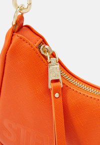 Orange handbag made of textured synthetic material, featuring a gold zipper and strap with hardware accents, showcasing a sleek triangular shape.