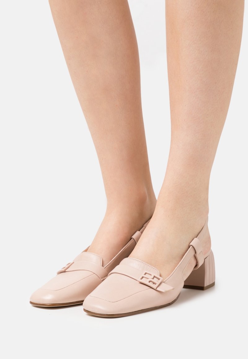 Chaussures slingback en cuir rose doux, avec un bout pointu, un talon carré texturé, et une sangle décorative avec une boucle d'accent.