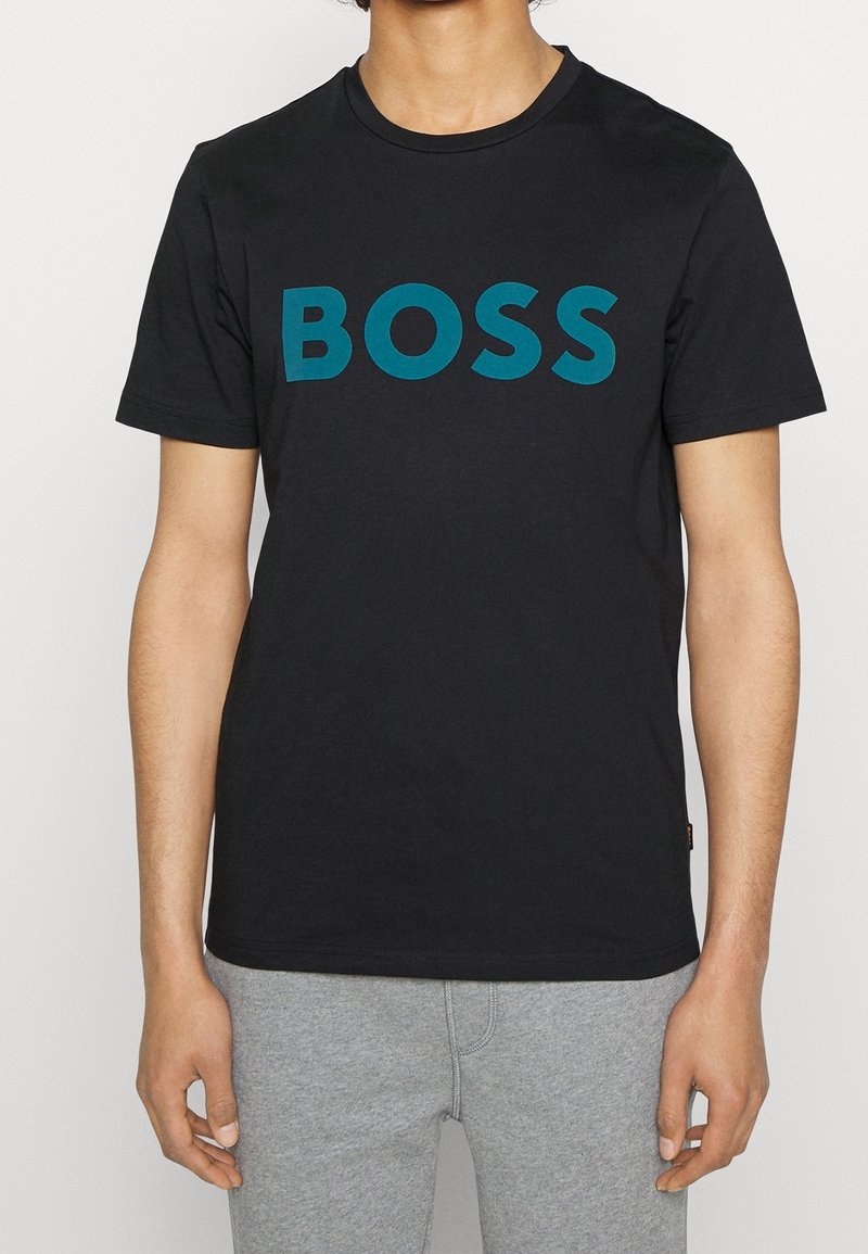 Svart bomull t-shirt med en djärv turkos "BOSS" logotyp på framsidan, rund krage och korta ärmar. Slät textur, figursydd design.
