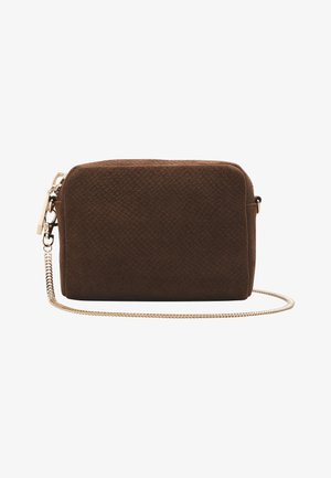 Pequeño bolso bandolera rectangular de ante marrón con una delgada cadena dorada y cierre de cremallera sobre un fondo blanco.