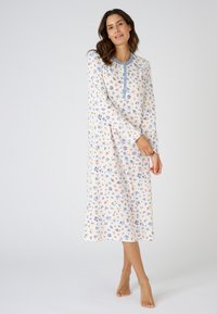 Vestido de noche de manga larga en tejido suave con un ligero estampado floral en azul y rosa sobre un fondo crema. Incluye un escote con botones.