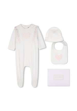 Ensemble bébé blanc avec grenouillère à pieds, bonnet et bavoir, tous ornés de motifs de cœurs rose clair, présenté avec une boîte blanche étiquetée Kenzo.