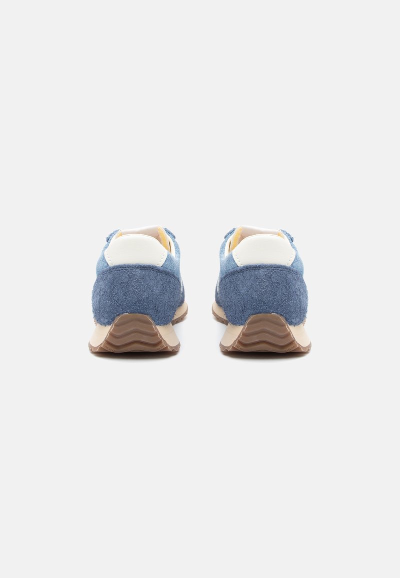 Blaue Wildledersneaker mit weißen Akzenten, einer strukturierten Rückseite und einer gewellten Gummisohle. Das Design zeichnet sich durch eine flache Silhouette und einen gepolsterten Schaft aus.