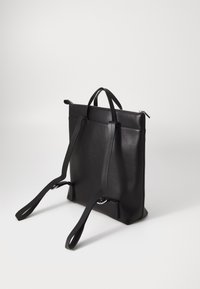 Zaino in pelle nera con spallacci regolabili, di forma rettangolare e apertura con zip. Presenta un design elegante e accenti hardware minimalisti.