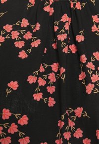 Il tessuto nero presenta un motivo floreale con piccoli fiori rosa e steli dorati, disposti in un design ripetuto. Materiale leggero e testurizzato.