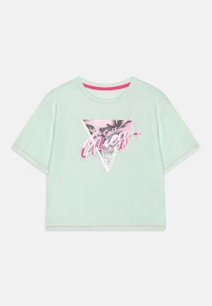 Kortærmet mintgrøn skjorte med pink og sølv trekantsgrafik med teksten "California Guess Est 1981" og palmebaggrund.