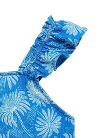 Blått tyg med ett blommönster som har vita palmblad. Samlad ruffle-detalj på axelremmen. Slät textur.