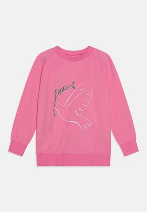 Sudadera rosa de manga larga con el contorno blanco de una paloma sosteniendo una rama de olivo verde y la palabra "paz" en letra cursiva verde.