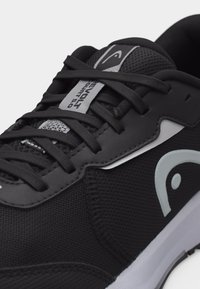Čierna športová obuv so sivým logom a štítkom, čierne šnúrky, zmes sieťoviny a syntetických materiálov, detail na prednú a bočnú časť zvršku.