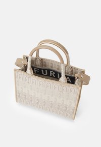 Kleine beige handtas met gestructureerd ontwerp, voorzien van een textuurpatroon en dubbele handvatten bovenaan. Interieur toont een zwart label met logo.