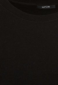Schwarzer Strickpullover aus strukturiertem Stoff mit rundem Ausschnitt. Das Etikett "OPUS" ist am Hals sichtbar. Einfaches und vielseitiges Design.