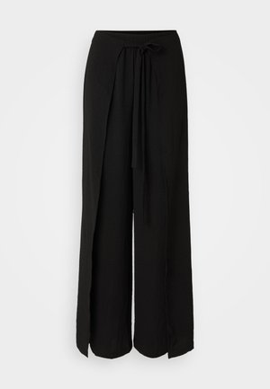 Black wide-leg pants made of lightweight fabric. Features an elastic waistband with a front tie and side slits at the hem.