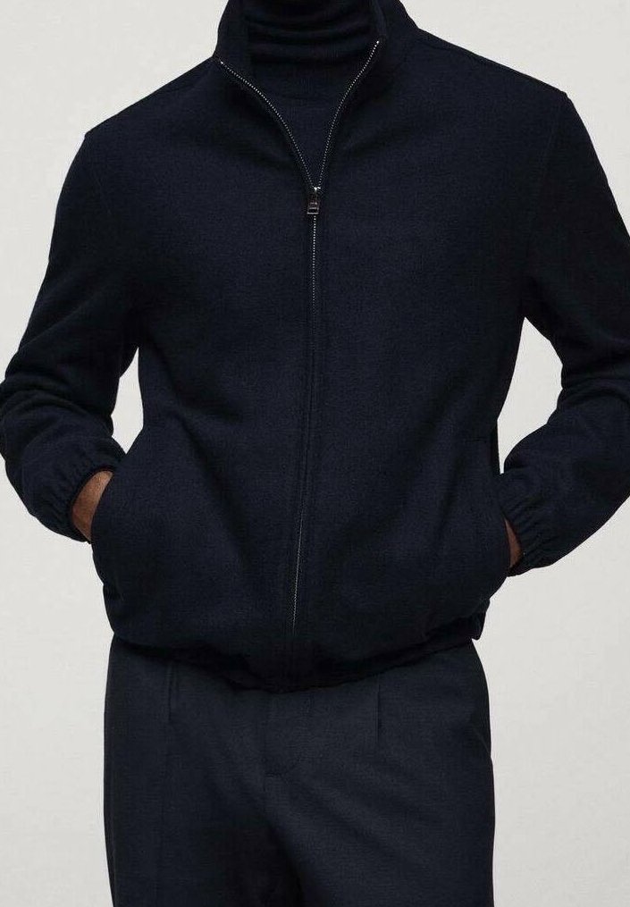 Navy zip-up jacket made from soft fabric, featuring a high collar, elastic cuffs, and two side pockets. Paired with matching dark trousers.