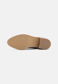 Suela de goma marrón con un patrón hexagonal texturizado, que cuenta con una puntera redondeada y material superior de color marino. Ideal para el uso casual.